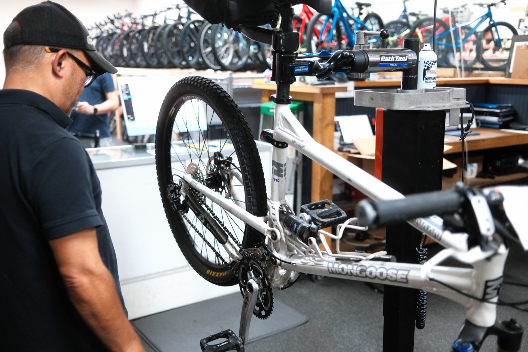 A mechanic working on a bike secured in a repair stand at Oscar's Bike Shop